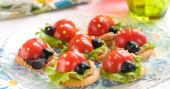 Adorable easy ladybug cracker appetizers with flavored cream cheese, crisp lettuce, and cherry tomatoes. A no bake party snack for gatherings.