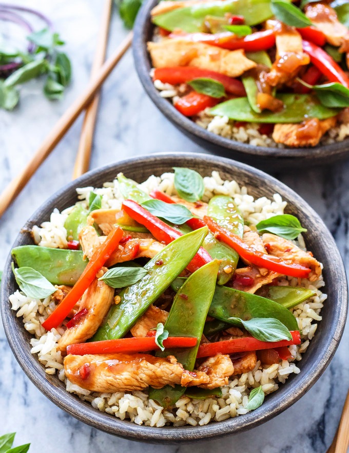 This Thai Chicken Stir Fry comes together in less than 30 minutes and is full of savory, sweet and spicy Thai flavors. Serve it over brown rice for a healthy takeout at home dinner!