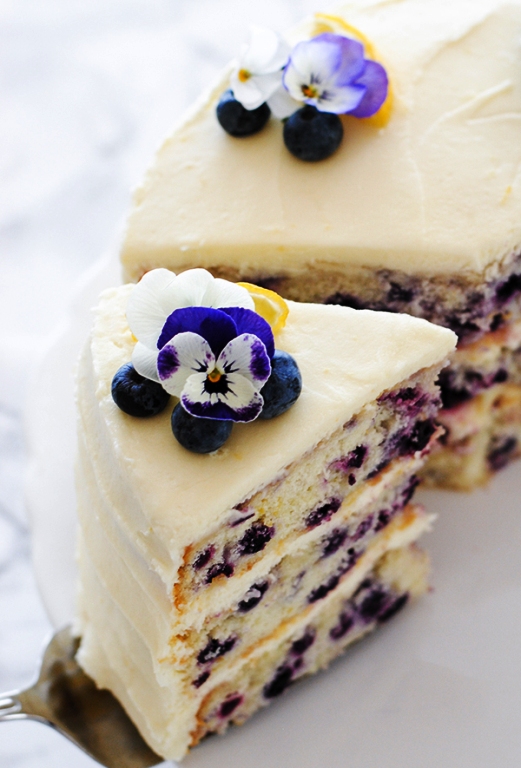 A tender layer cake recipe brightened with lemon juice, lemon zest and wild blueberries, frosted with a tangy sweet lemon cream cheese frosting.