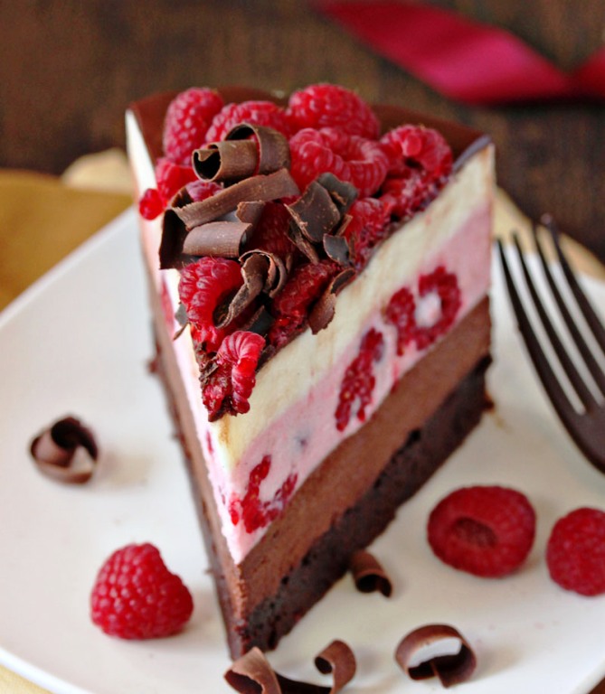 This stunning Chocolate Raspberry Mousse Cake has a moist, fudgy brownie base, three layers of light mousse—chocolate, raspberry, and vanilla, and then a glossy topping of chocolate and a tangle of raspberries and chocolate curls on top. Perfect for any occasion!