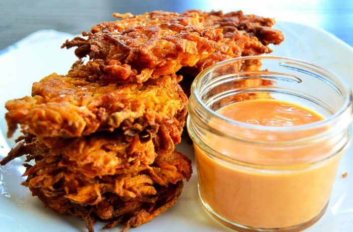 Sweet potato fritters are lightly seasoned with ginger, cinnamon, and fennel, then pan-fried until crispy on the outside and soft on the inside. Pair with the homemade sweet and spicy sauce for a decadent dipping experience.