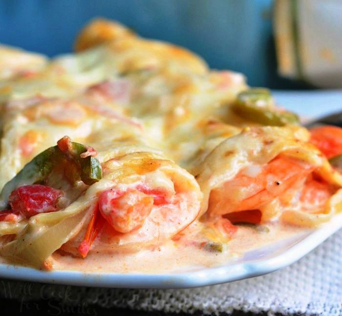 Shrimp Enchiladas are a delicious seafood dish that is easy to prepare and ready in under 45 minutes. Cheesy, creamy seafood enchiladas are packed with large shrimp, jalapenos, onions, tomatoes and all baked in spicy, creamy sauce.