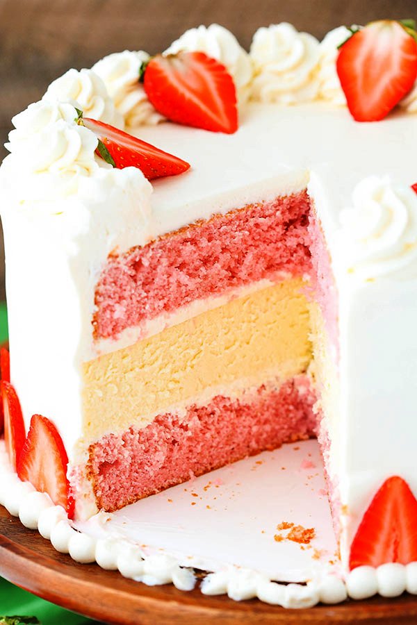 This Strawberries and Cream Cheesecake Cake is perfect in every way! With two layers of strawberry cake and a creamy layer of vanilla cheesecake in the middle, this cake is no joke.