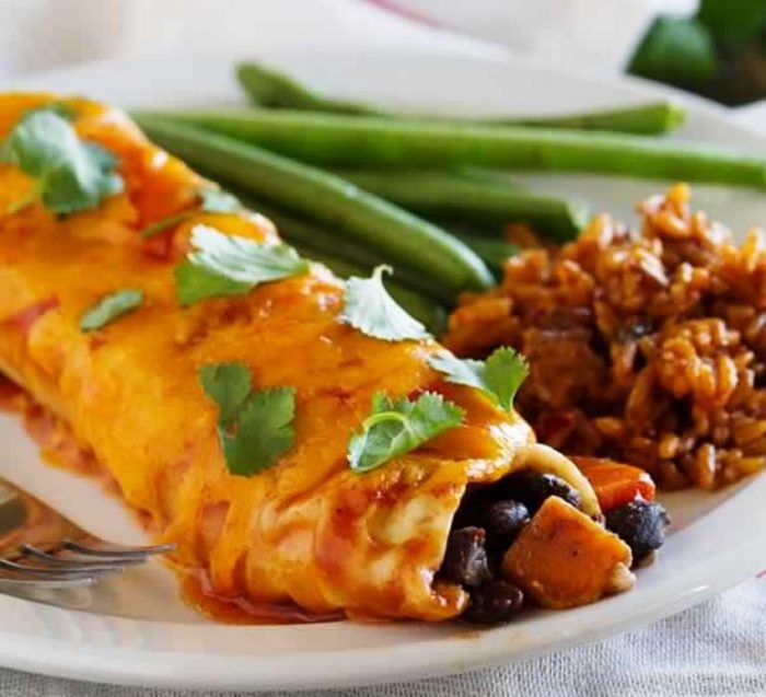 These vegetarian Sweet Potato and Black Bean Enchiladas are packed with flavor – perfect for a Tex-Mex dinner on a budget!