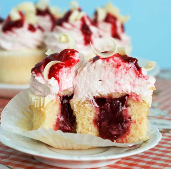 White Chocolate Strawberry Cupcakes are moist and dense vanilla cupcakes with strawberry filling! Top these decadent cupcakes with a layer of melted white chocolate and some strawberry-white chocolate cream cheese frosting.