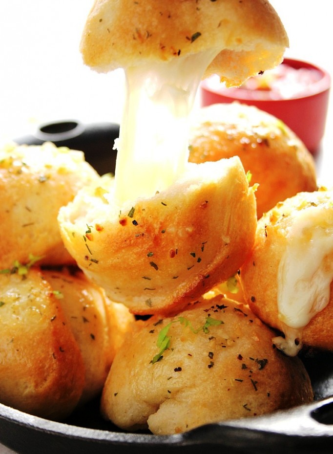 Easy Garlic Cheese Bombs Recipe - biscuit bombs filled with gooey mozzarella, brushed with garlic Ranch butter and baked into perfection. Easy, fast and absolutely addicting!