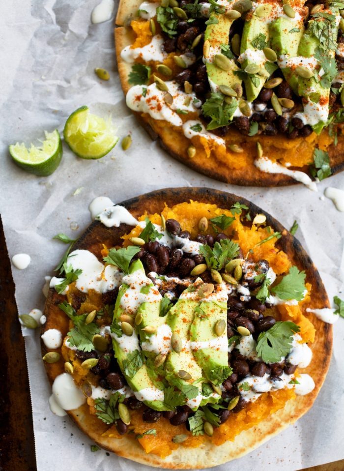 one day recently I realized I was out of tortillas and decided to toast a round of pita bread and used it as a chewier base for tostada toppings. And the result was a total “why didn’t I think of this before?” moment. The golden-brown crust is a perfect canvas for all kinds of toppings: mozzarella and tomato, hummus and red peppers, or in this Mexican-themed version, butternut squash, black beans, and avocado. 