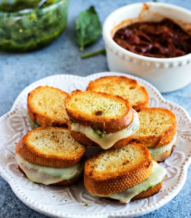 Mini Pesto Grilled Cheese – Fresh basil pesto and sliced provolone cheese are sandwiched into a crusty baguette and grilled to perfection to make the best appetizer for any event. Don’t forget to serve with homemade garlic butter tomato sauce for dunking!