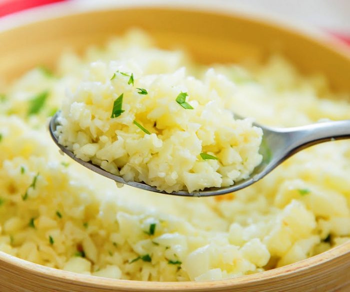 Cauliflower rice is cooked with a garlic butter sauce and Parmesan cheese for a low carb, gluten free, delicious and easy dish.