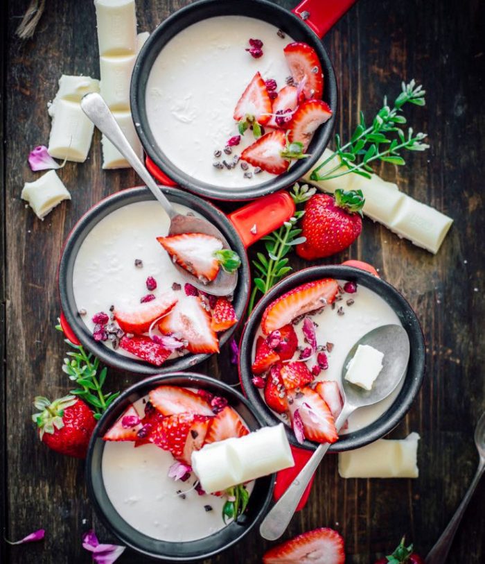 White Chocolate Panna Cotta served with fresh strawberries, dried pomegranate seeds and cocoa nibs for a delicious sweet treat that comes together in minutes and is also gluten free.