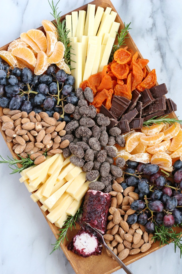 To help you celebrate the holidays in style, I’m sharing how to build a beautiful appetizer platter, filled with fruit, cheese, nuts and chocolates.
A gourmet appetizer platter like this is sure to be a welcome sight at any holiday party!