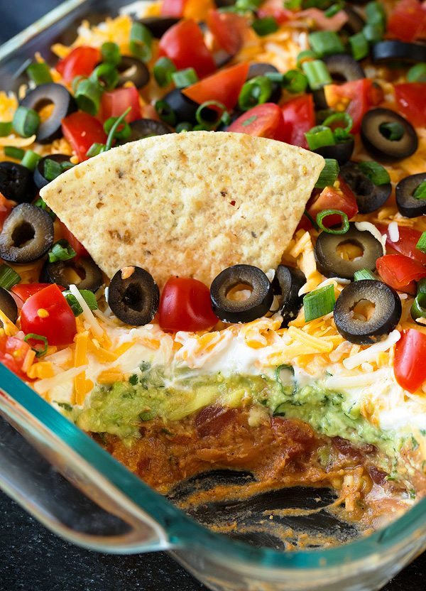 This 7 Layer Dip is the ultimate party food and game day food! It’s jam packed with layers of fresh flavor and makes the best snack. It’s one of our favorite dip recipes and it’s perfectly easy to make, no cooking required!