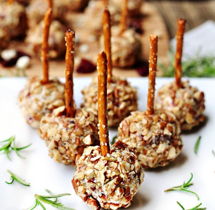 Mini Cheese Balls are studded with dried cranberries and blue cheese, rolled in toasted pecans, and skewered with pretzel sticks for a fun and easy party appetizer!