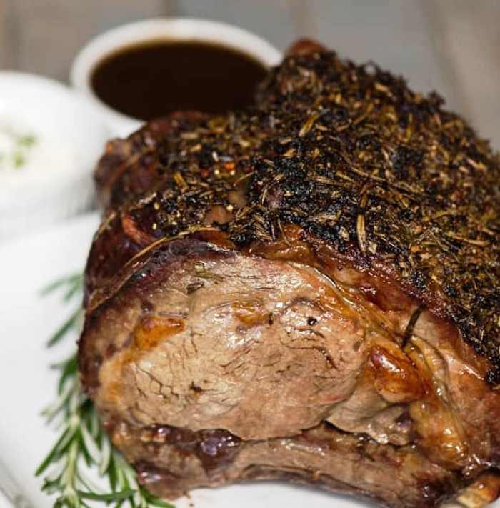 Prime Rib Roast is a favorite for holiday dinners. If you want to know how to cook a the most mouthwatering tender roast with a flavorful fresh herb crust and divine rich wine sauce, everything you need to know to get perfect results every time is below.