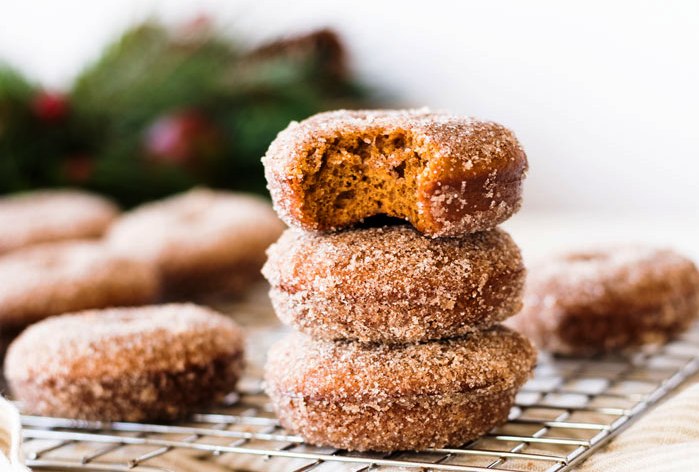 Gingerbread donuts are a festive way to celebrate Christmas morning. Coated in cinnamon sugar, these baked donuts are easy to make in a donut tin.
