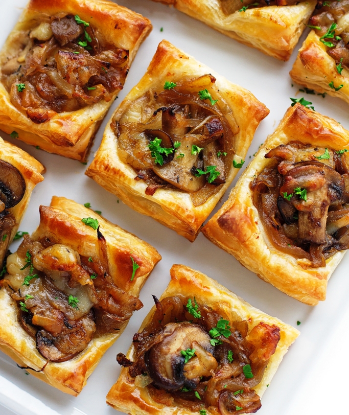 Caramelized onion bites with sautéed crimini mushrooms, balsamic caramelized onions, and applewood smoked gruyere cheese. The perfect little appetizers! They’re made with puff pastry and take no time at all to whip up! These are the perfect appetizers to serve your guests this holiday season.