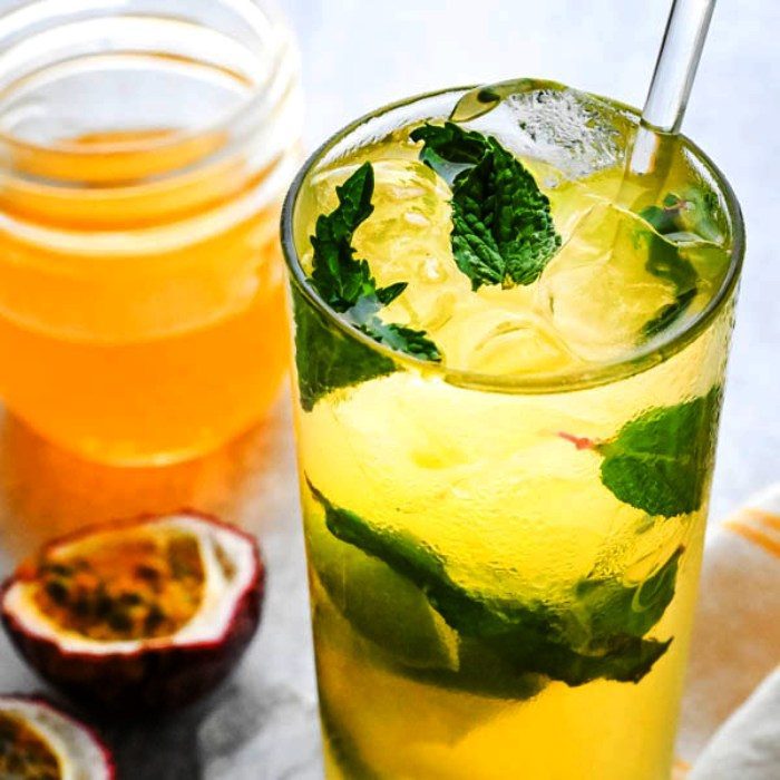 This easy mojito recipe is tropical and light with muddled lime and mint leaves plus a floral, sweet passion fruit syrup. This simple rum drink can be made by the glass or pitcher, but I’d opt for a pitcher of  Passion Fruit Mojitos if you’ve got more than two people. We top our passion mojitos with a spot of sparkling water or club soda because… bubbles!