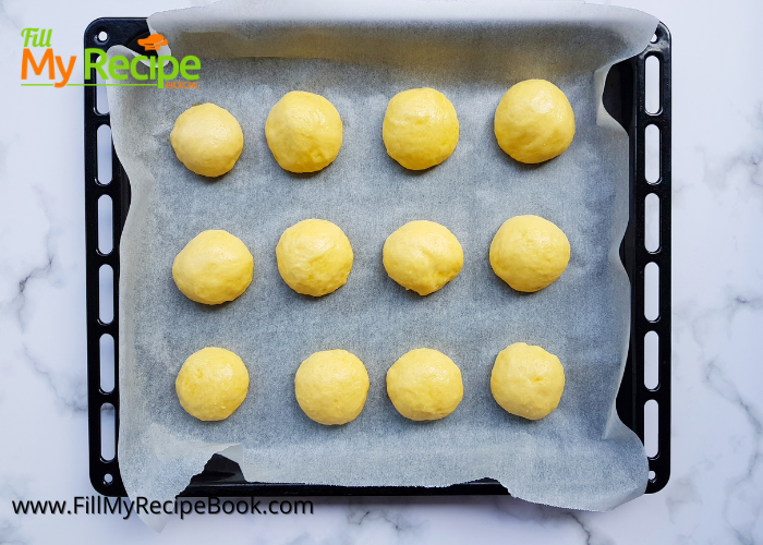 dough process of making small rolled balls on a baking tray of cream cheese kolache