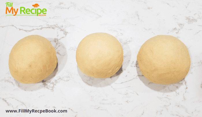rolling the dough mixture into three balls once it has risen to make braids for the loaf
