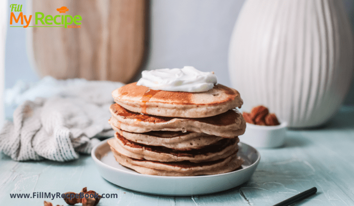 A plate of maple syrup drizzled pancakes in a tower with a dollop of cream on top 