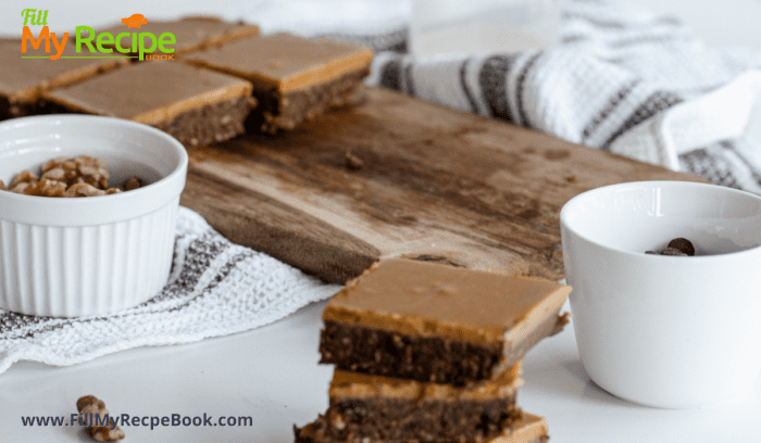 raw brownies with caramel on top served and slices on a board with nuts and chocolate chips