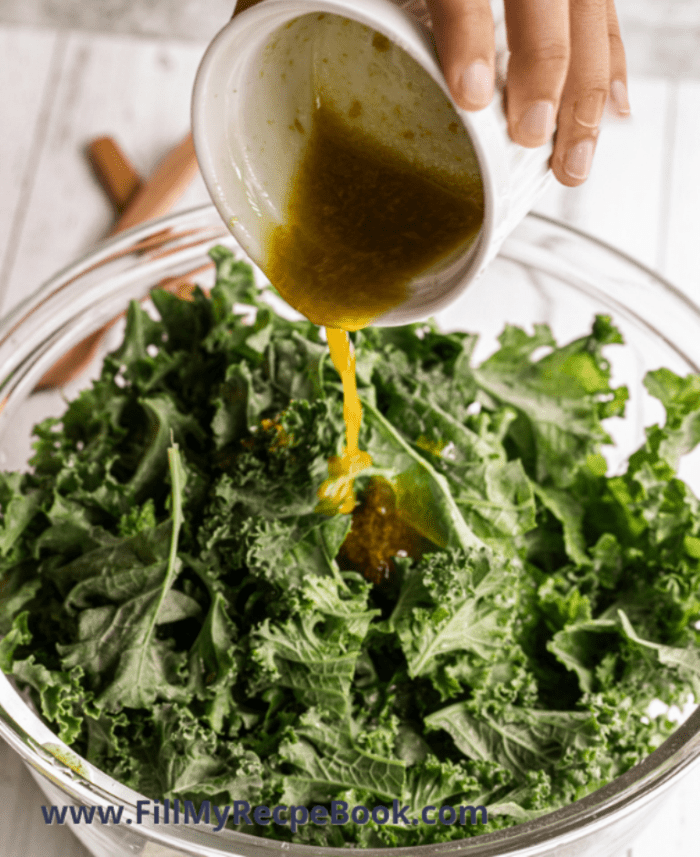 mixed ingredients poured over the fresh kale for chip baking