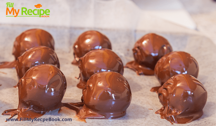 truffles just been coated with chocolate and layed on a baking sheet