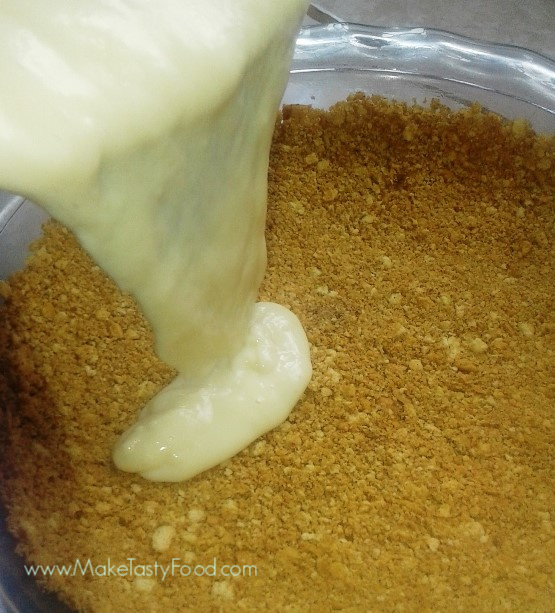 pouring the thickened milk over the biscuit crust 