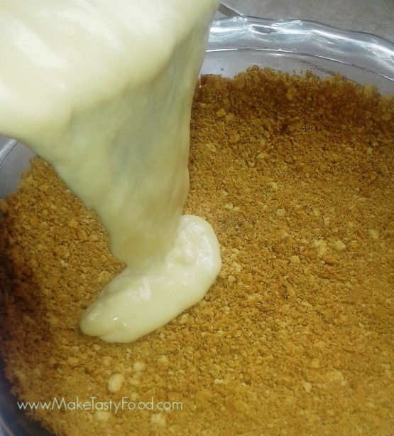 pouring the thickened milk over the biscuit crust