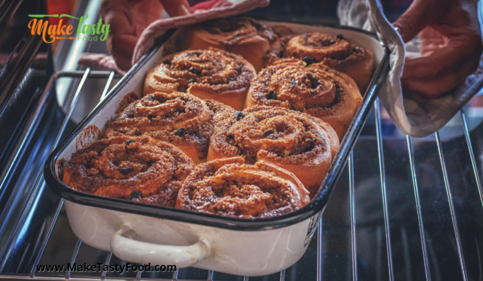 A casserole dish with cinnamon sprinkled rolls finished baking in a oven