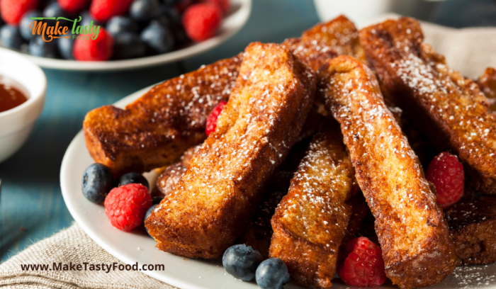 french toast on a plate with berries and drizzled honey