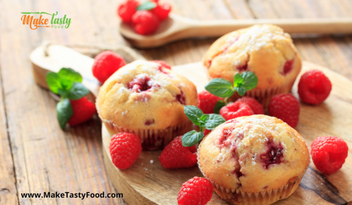 raspberry muffins with fresh raspberries placed on a board