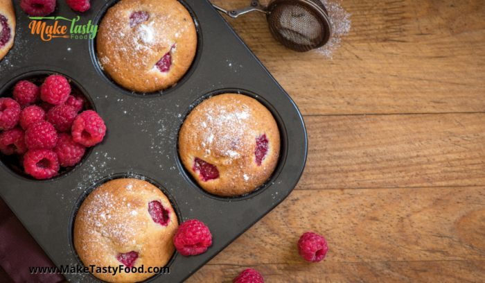 a muffin pan with the freshly baked raspberry muffins.