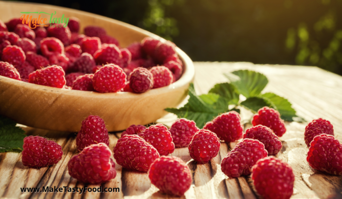 picked raspberries on a board from the raspberry bushes on the farm