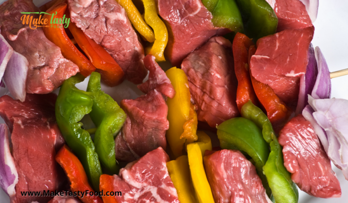 made beef and peppers and onion sosatie that are uncooked and ready to marinate.