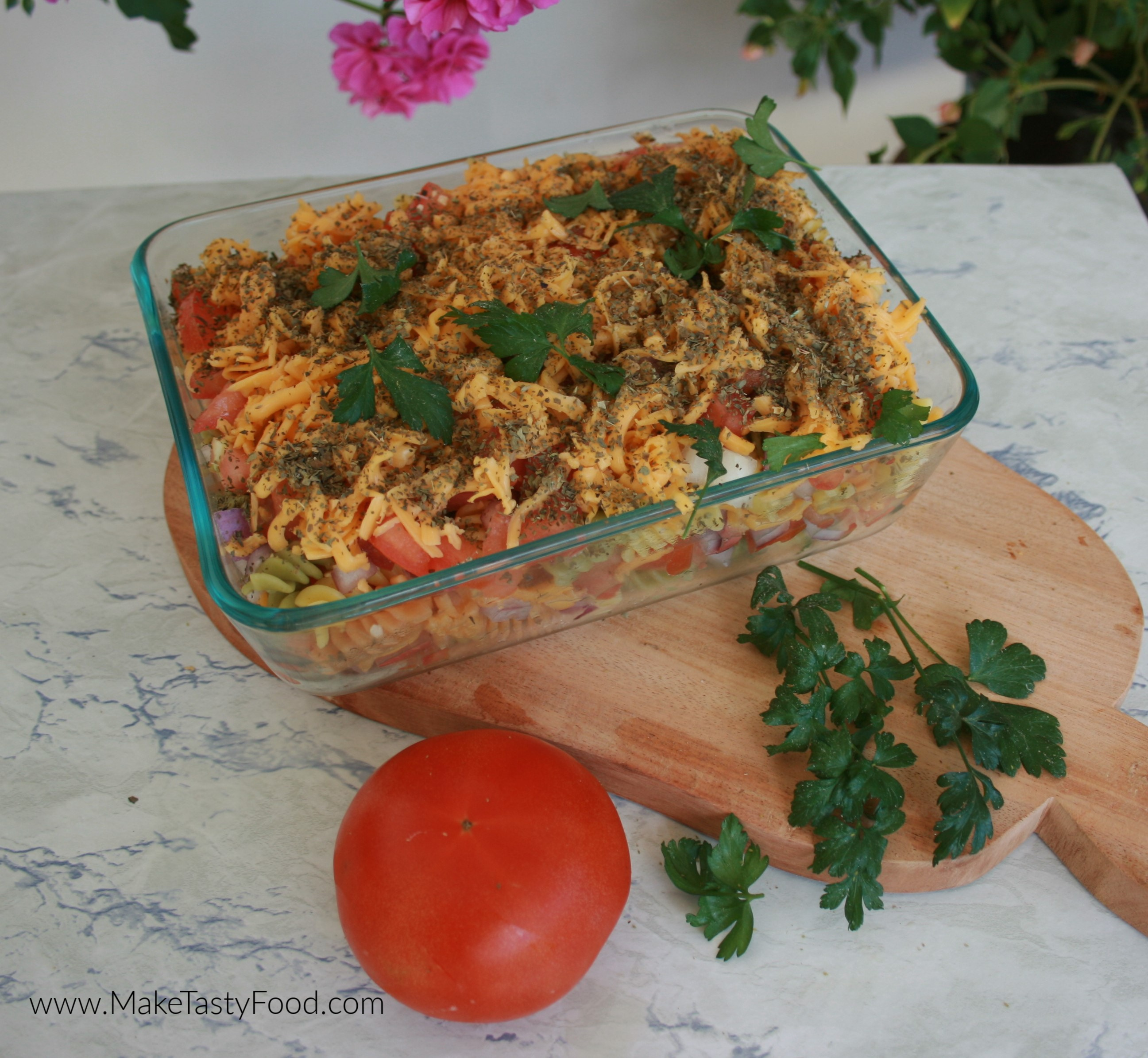 The dish layered with pasta and tomato and cheese ready to have the egg and milk poured in.