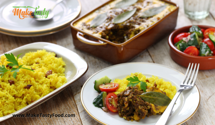 a casserole of bobotie and yellow rice with salad for a meal