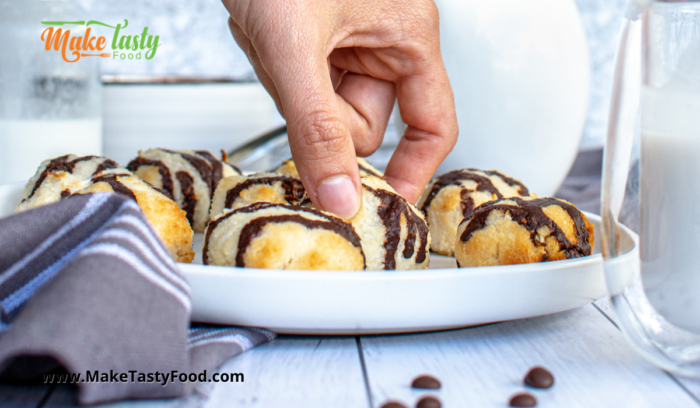 chocolate drizzled coconut macaroons served on a plate