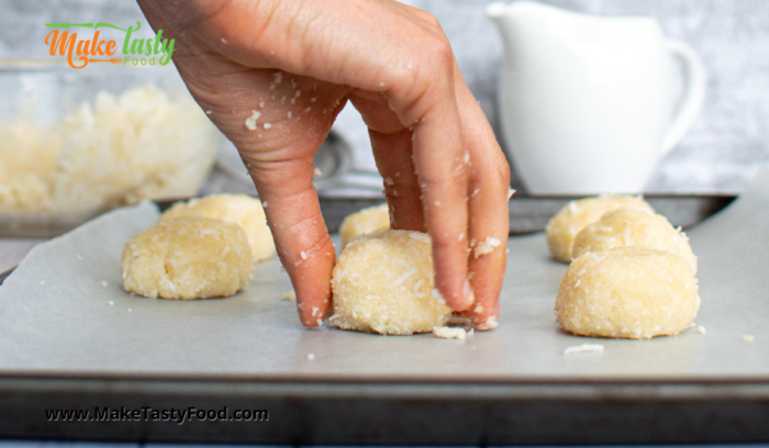 placing a rounded coconut macaroon on a baking sheet