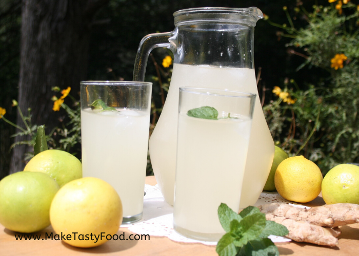 two glasses of ginger beer and a jug full of lemon and ginger beer