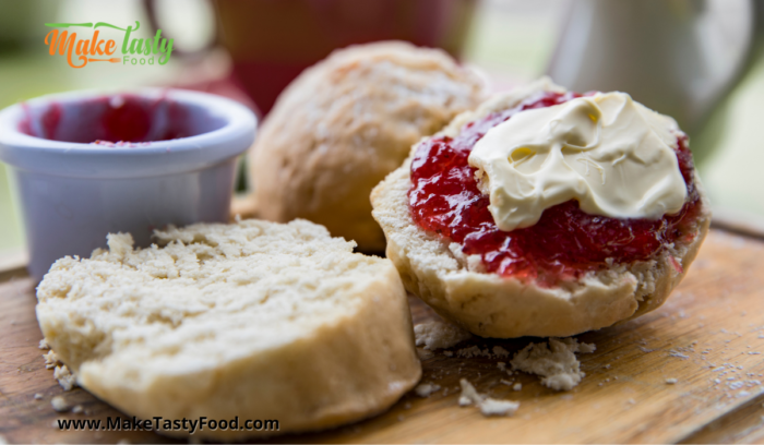 scones cut into halves with jam and cream spread on