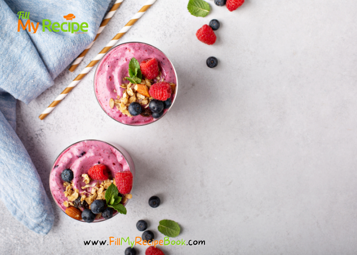 a healthy berry filled colorful smoothie topped with raspberries and blueberries and muesli  mix and a sprig of mint
