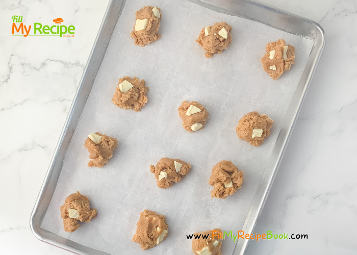 preparing to bake the cookies with the dough rolled in balls place on the line baking sheet. 
