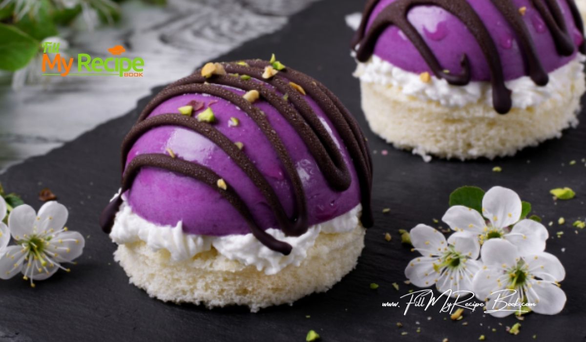 Mini Blueberry Mousse Cakes Glazed and decorated with chocolate and cream. Base is a almond sponge cake with blueberry mousse fillings.