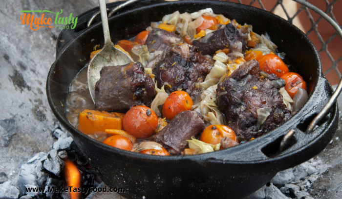 A Tasty Oxtail Potjie Recipe features a tender piece of meat braised in a flavorful gravy and vegetables, served on rice or with pot bread.