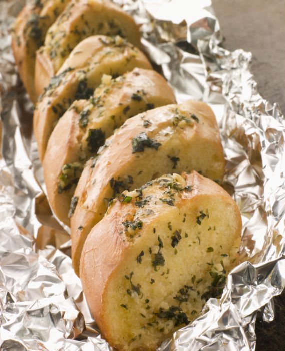 Homemade Garlic Braai Loaf recipe. Easy idea of a loaf, sliced stuffed with garlic, butter and parmesan cheese for starters, grilled in foil.