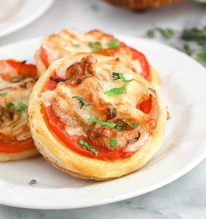 This Easy Tomato Tarts Recipe on Puff Pastry adds tender caramelized onions, fresh tomato, and spiced Pepperjack cheese to the flakiest mini butter crust!  They are perfect for serving on a whim and impressing your guests. 