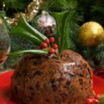 Traditional Christmas Pudding Recipe to create. A delicious steamed fruit dessert with brand, treacle and spices in a bowl, serve with sauce.