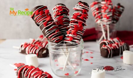 Simple Marshmallow Pops for Valentine’s idea for kids. Stack three marshmallows on a stick, dip in chocolate, and add heart sprinkles.