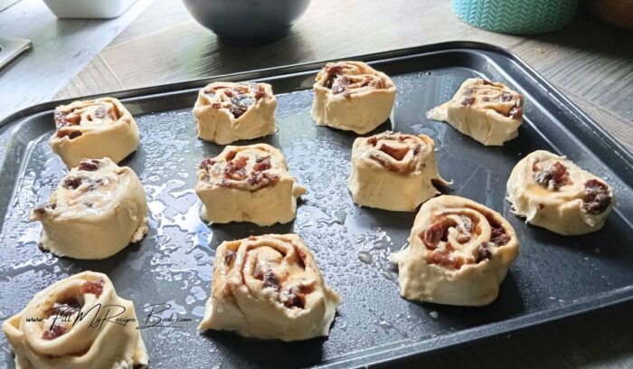 Place your sliced puff pastry raisin slices on the greased sheet pan tray. Keep them about an inch apart for them to expand.